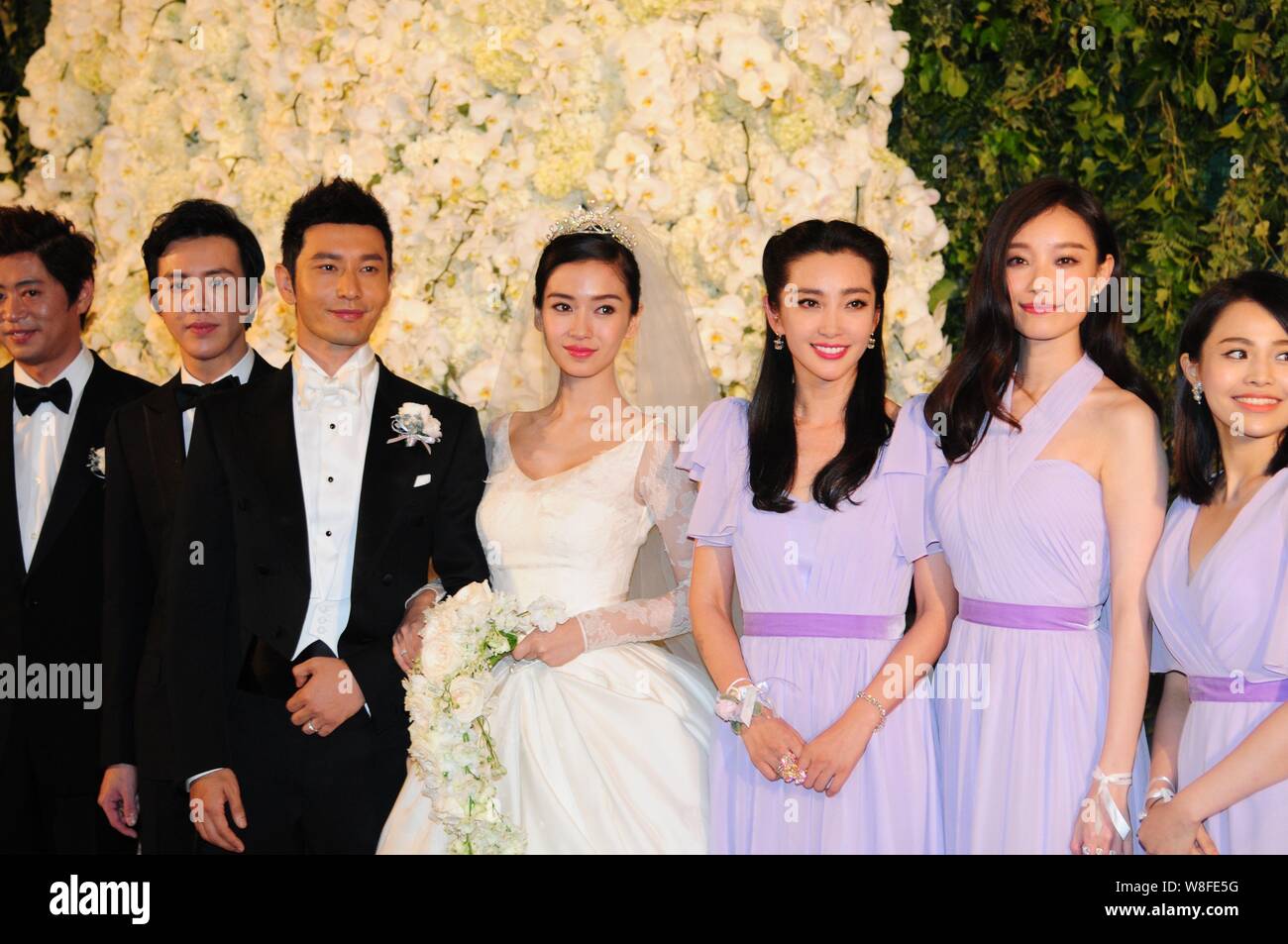 Attore cinese Huang Xiaoming, la terza a sinistra e la sua attrice moglie Angelababy, quarta a destra, rappresentano con la loro groomsmen e damigelle durante il loro weddin Foto Stock