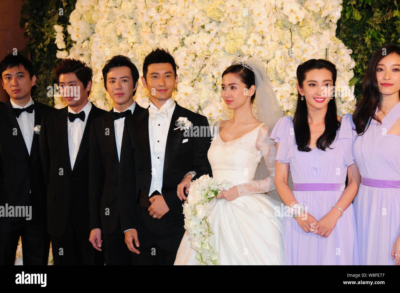 Attore cinese Huang Xiaoming, la quarta a sinistra e la sua attrice moglie Angelababy, la terza a destra, rappresentano con la loro groomsmen e damigelle durante il loro weddin Foto Stock