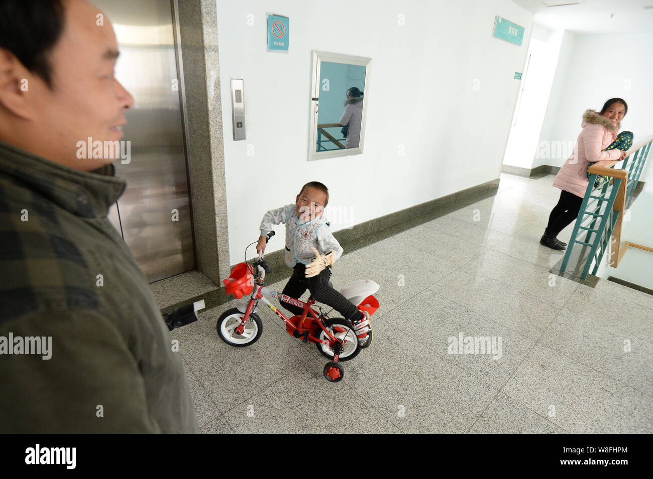 5-anno-vecchio ragazzo Xiaohu, centro ride come egli si prepara a guidare la sua bicicletta con un 3D stampata a mano sinistra a Wuhan terzo ospedale nella città di Wuhan, centra Foto Stock