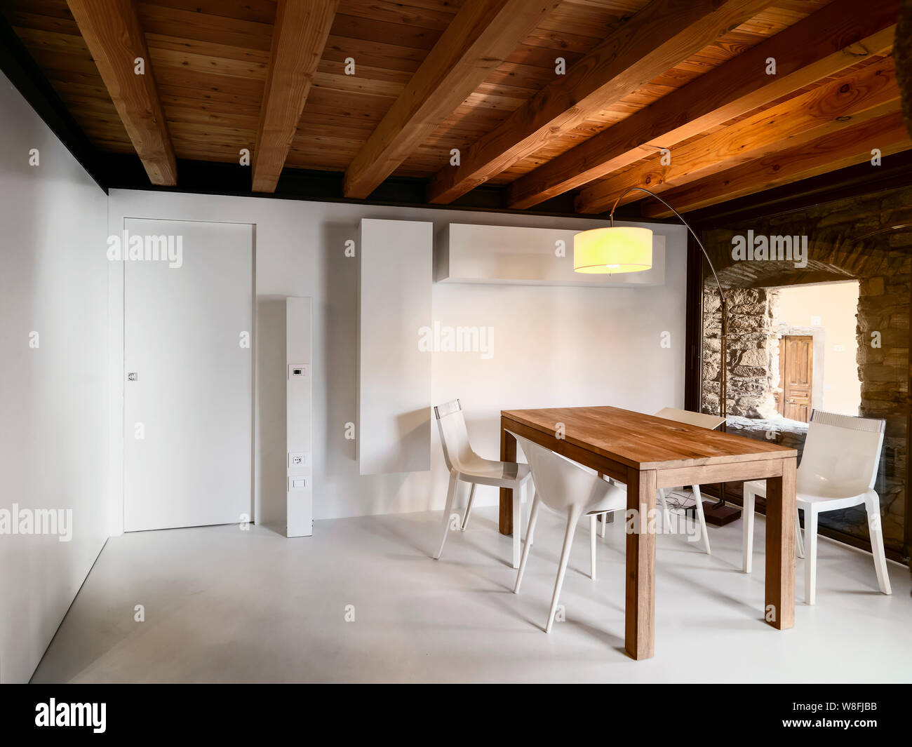 Gli scatti in interni di una moderna sala da pranzo con un tavolo di legno del soffitto in legno e il pavimento realizzato in resina Foto Stock