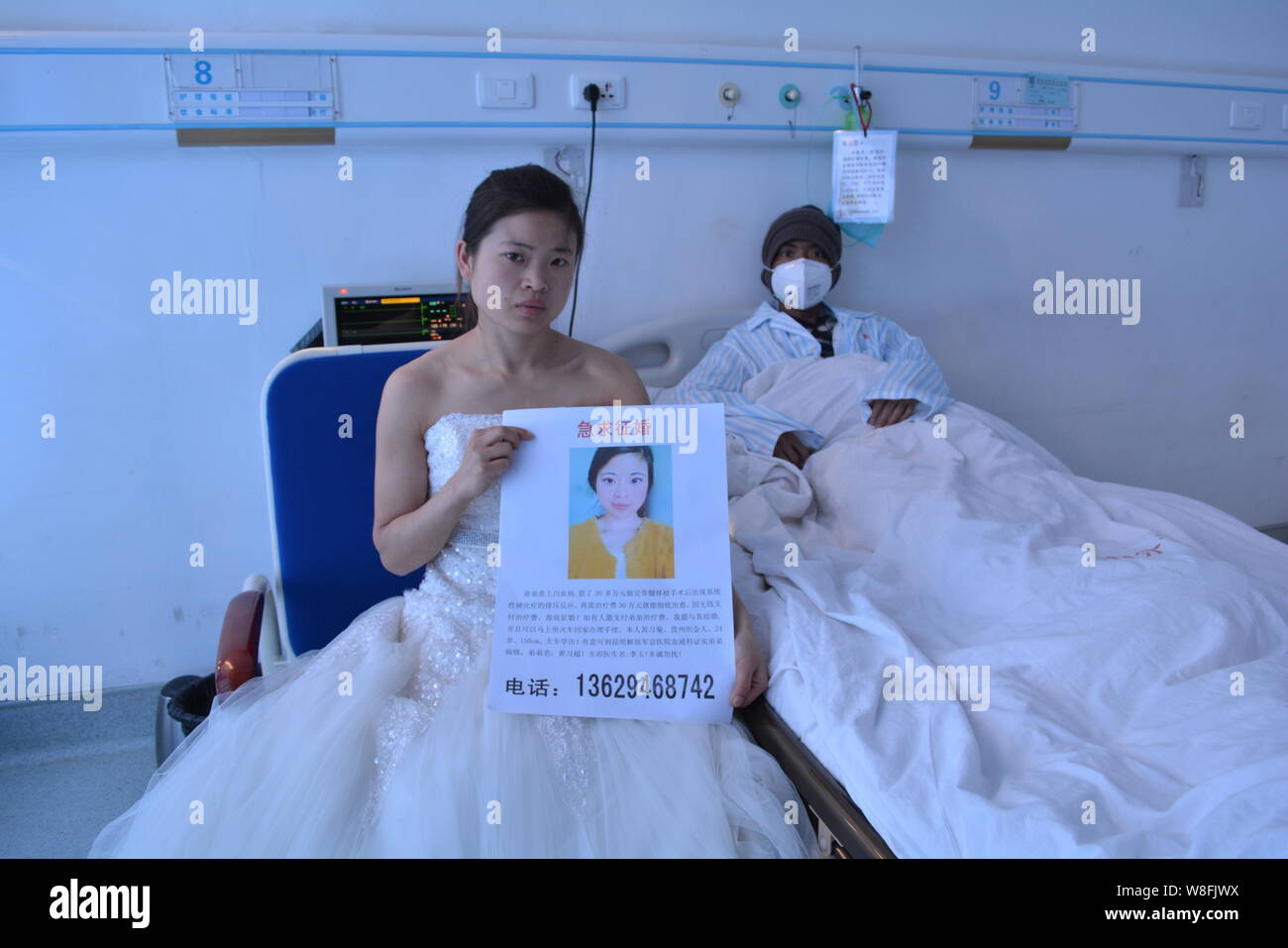 24-anno-vecchio Huang Xiju in un bianco abito da sposa, mostra un segno per cercare un marito che è disposto a pagare le spese mediche del suo leucemia-colpite Foto Stock