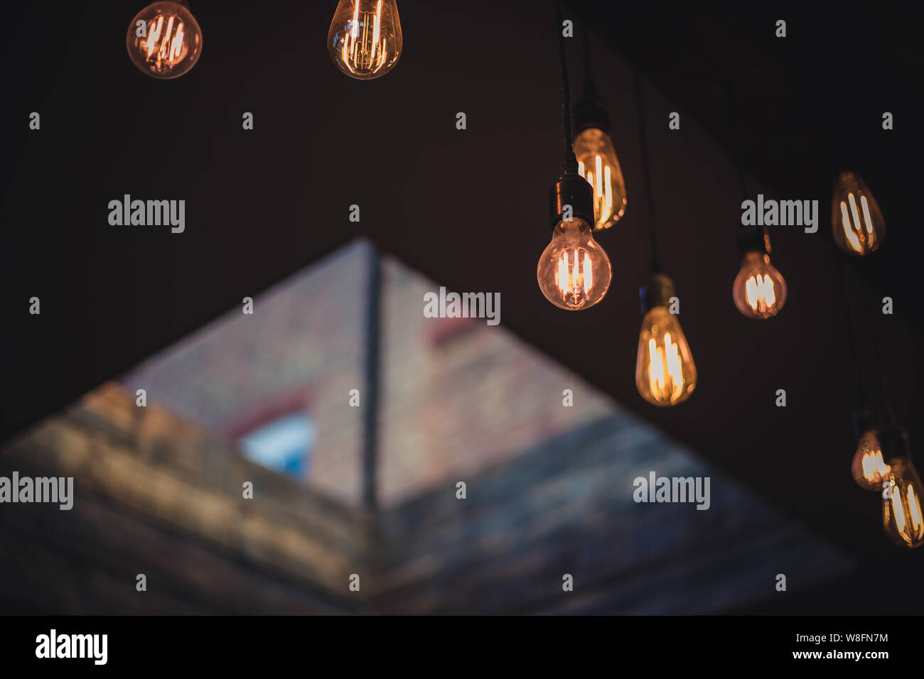 Lampadine con il filamento che pendevano dal soffitto e incandescente in un moderno bar. Kent, Regno Unito Foto Stock