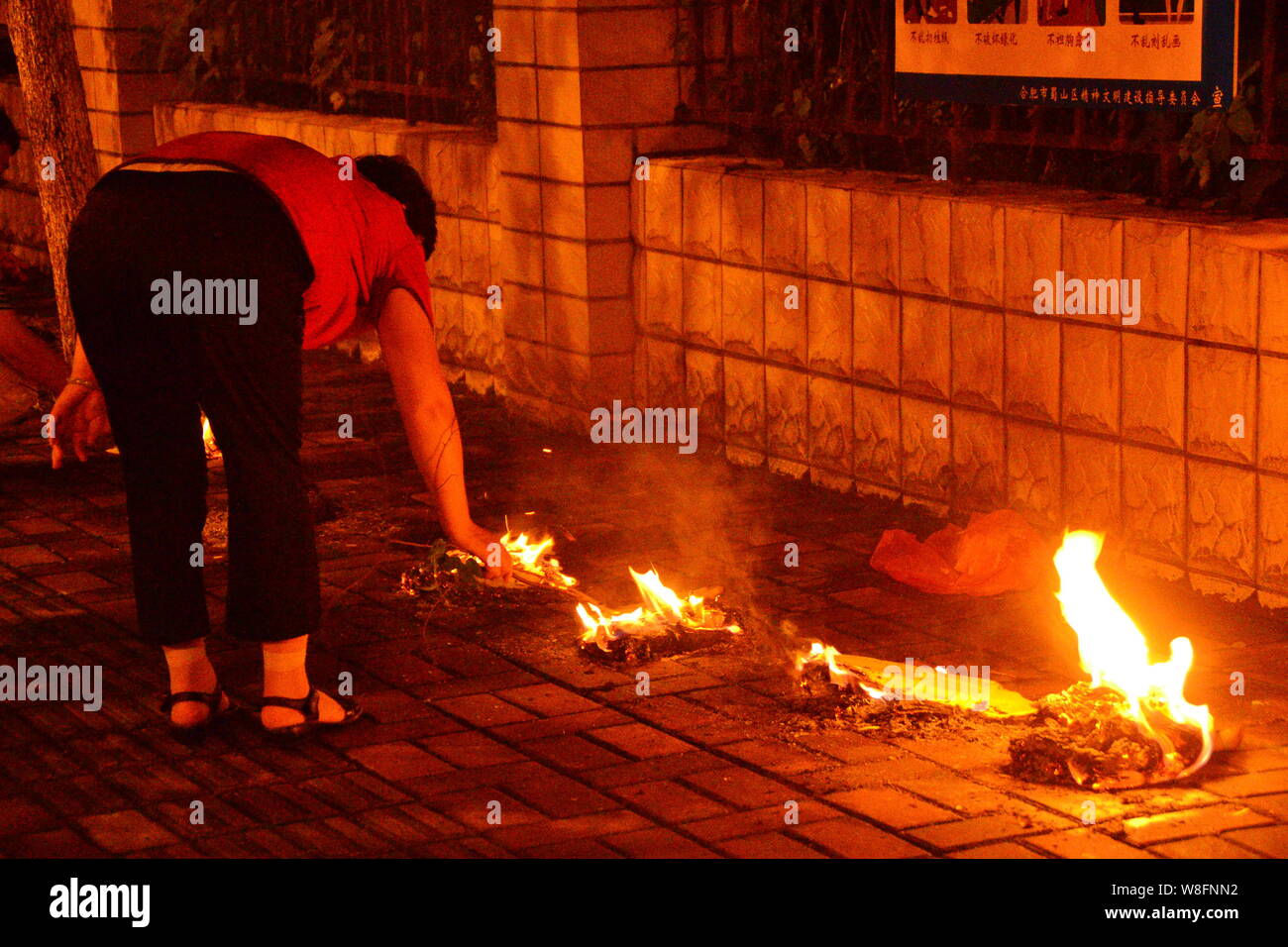 --FILE -- Un locale residente cinese brucia joss carta moneta a piangere i suoi parenti su una banchina in Ghost Festival nella città di Hefei, Cina orientale¯s Anhui p Foto Stock