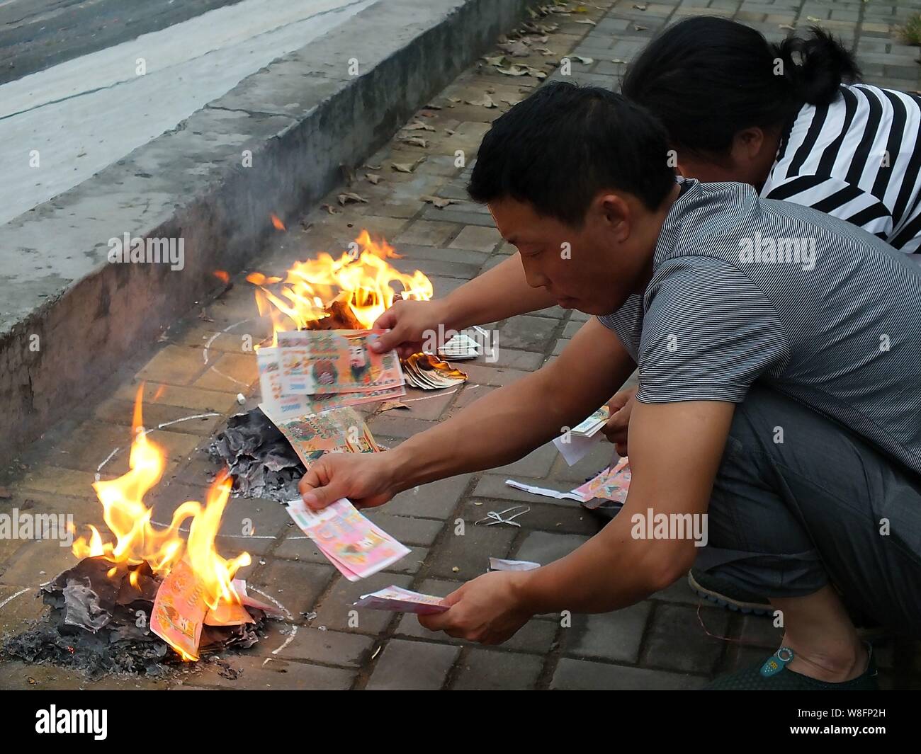 --FILE--Cinesi locali residenti masterizzare joss carta moneta a piangere i loro parenti lungo un argine a Yichang city, centrale cinese della provincia di Hubei, 8 Ma Foto Stock