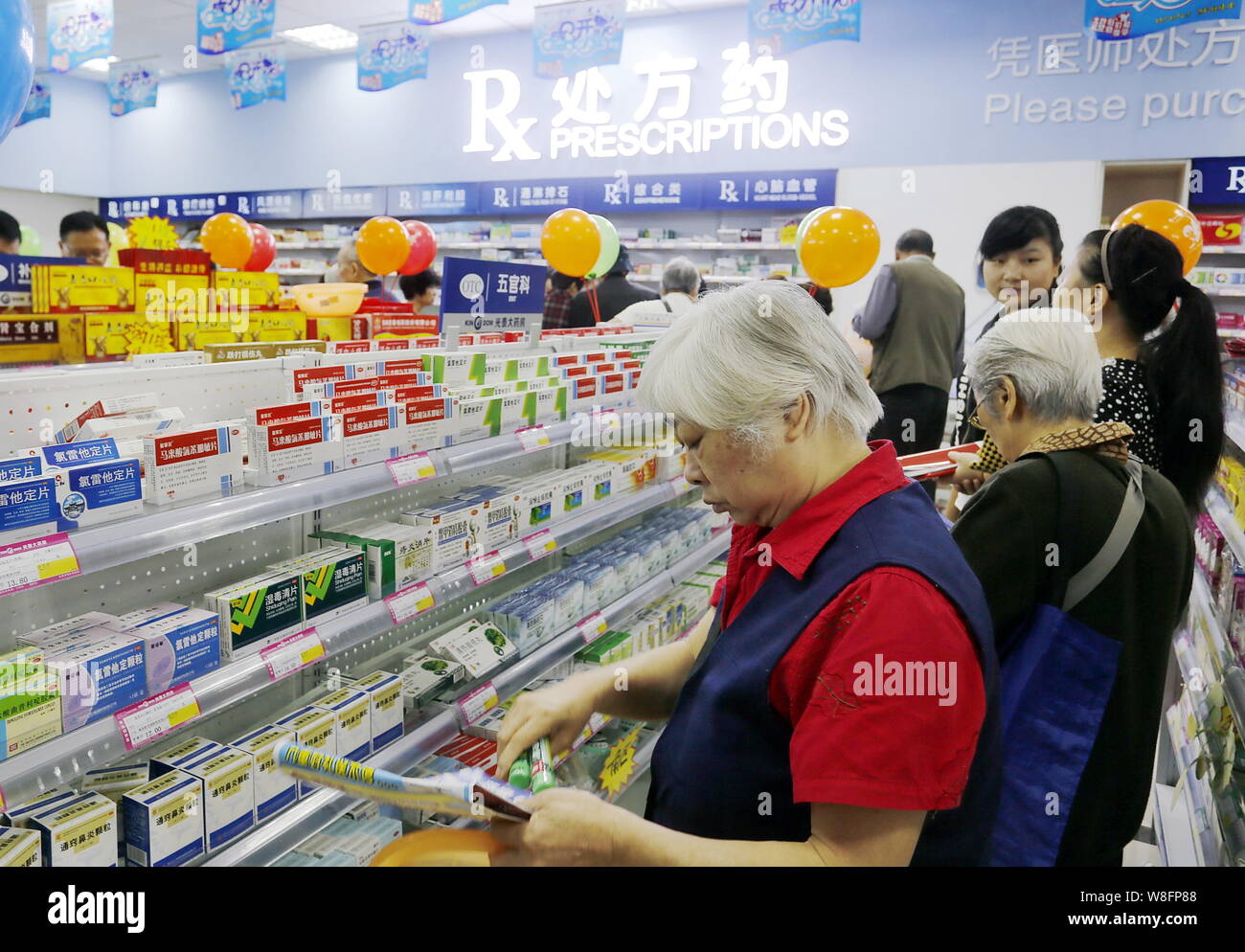 --FILE--Cinesi locali residenti comprare medicine in farmacia in Yichang city, centrale cinese della provincia di Hubei, 19 settembre 2014. La Cina sarà rimuovere pr Foto Stock