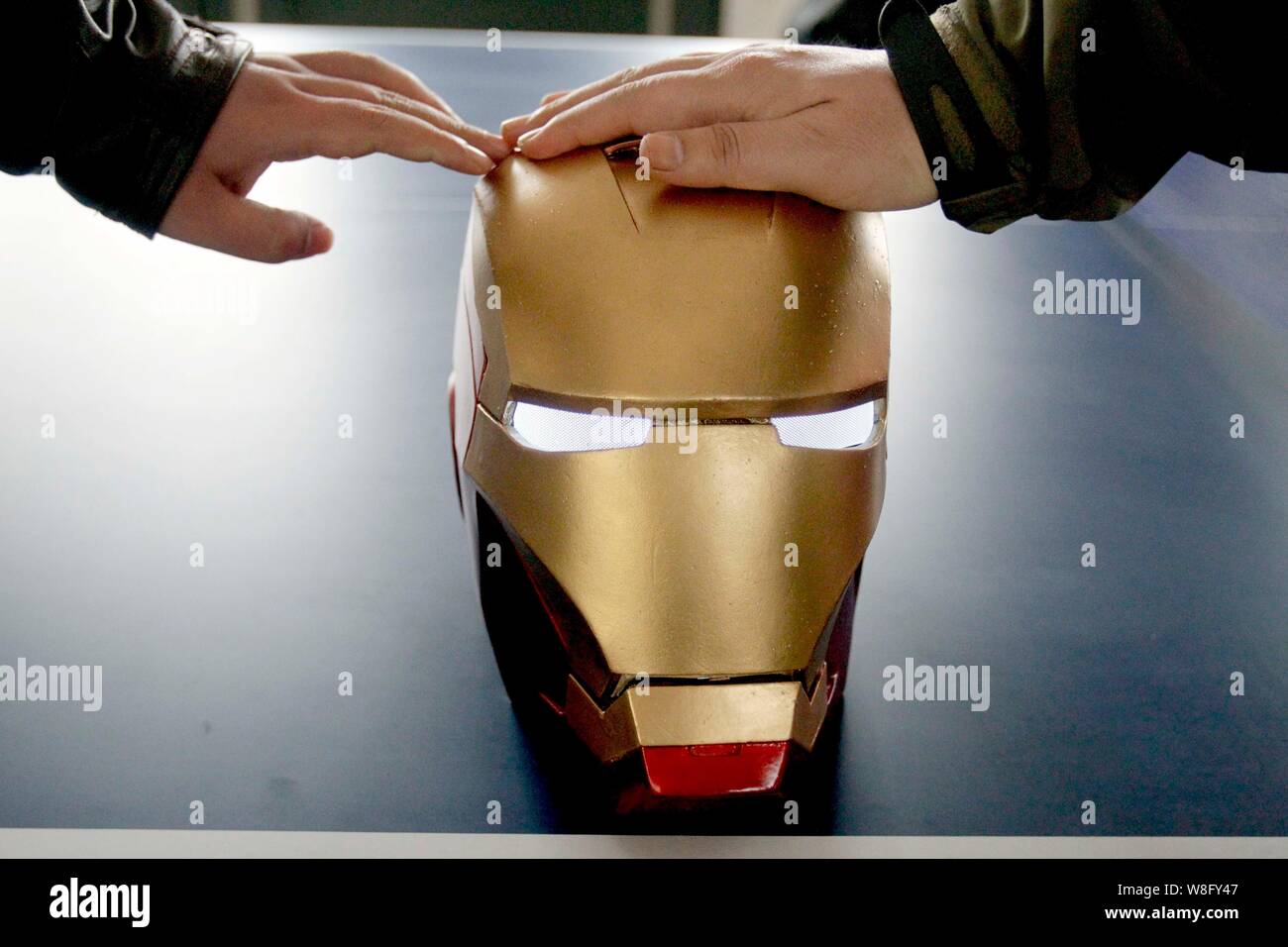 Il casco di cinesi "l'uomo del ferro" fan Cheng Chen di plastica in casa Iron Man armor è raffigurato nella sua casa nella città di Xuzhou, est della Cina di Jiangsu provinc Foto Stock