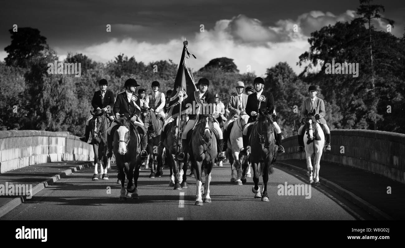 Coldstream, Scottish Borders, Scozia, Regno Unito, 8 agosto 2019. Il 2019 Coldstreamer Jono Wallis conduce la cavalcata attraverso la frontiera scozzese su Coldstream Bridge da Flodden dopo l annuale rideout (al sito del 1513 battaglia in cui James IV è stato battuto da l'inglese), durante Coldstream Civic settimana. Il comune di confine circoscrizioni che inizia con Berwick e continuare per tutta l'estate con altre città di frontiera tenendo il loro (Hawick, Selkirk, Jedburgh Kelso, Duns e Lauder) con Coldstream essendo l'ultimo. Foto Stock