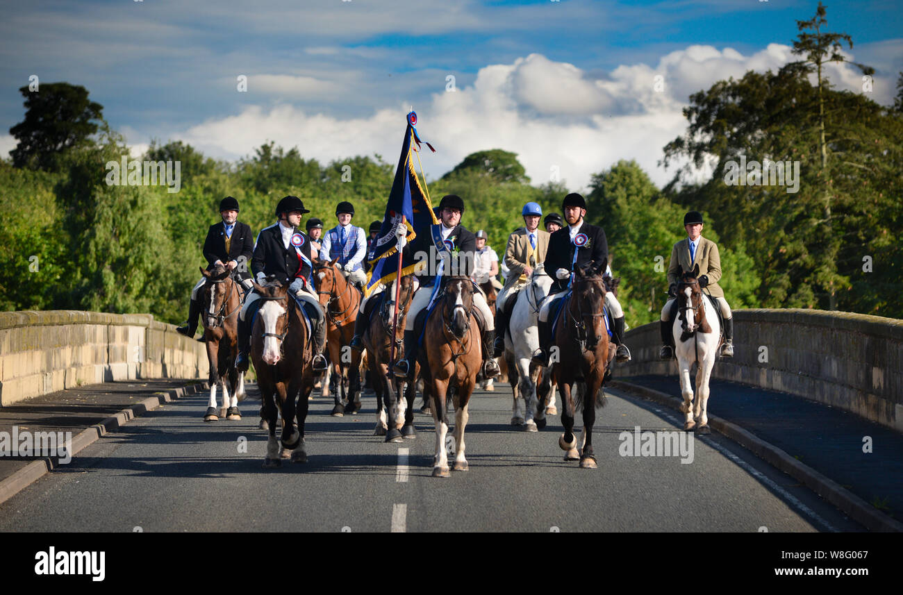 Coldstream, Scottish Borders, Scozia, Regno Unito, 8 agosto 2019. Il 2019 Coldstreamer Jono Wallis conduce la cavalcata attraverso la frontiera scozzese su Coldstream Bridge da Flodden dopo l annuale rideout (al sito del 1513 battaglia in cui James IV è stato battuto da l'inglese), durante Coldstream Civic settimana. Il comune di confine circoscrizioni che inizia con Berwick e continuare per tutta l'estate con altre città di frontiera tenendo il loro (Hawick, Selkirk, Jedburgh Kelso, Duns e Lauder) con Coldstream essendo l'ultimo. Foto Stock