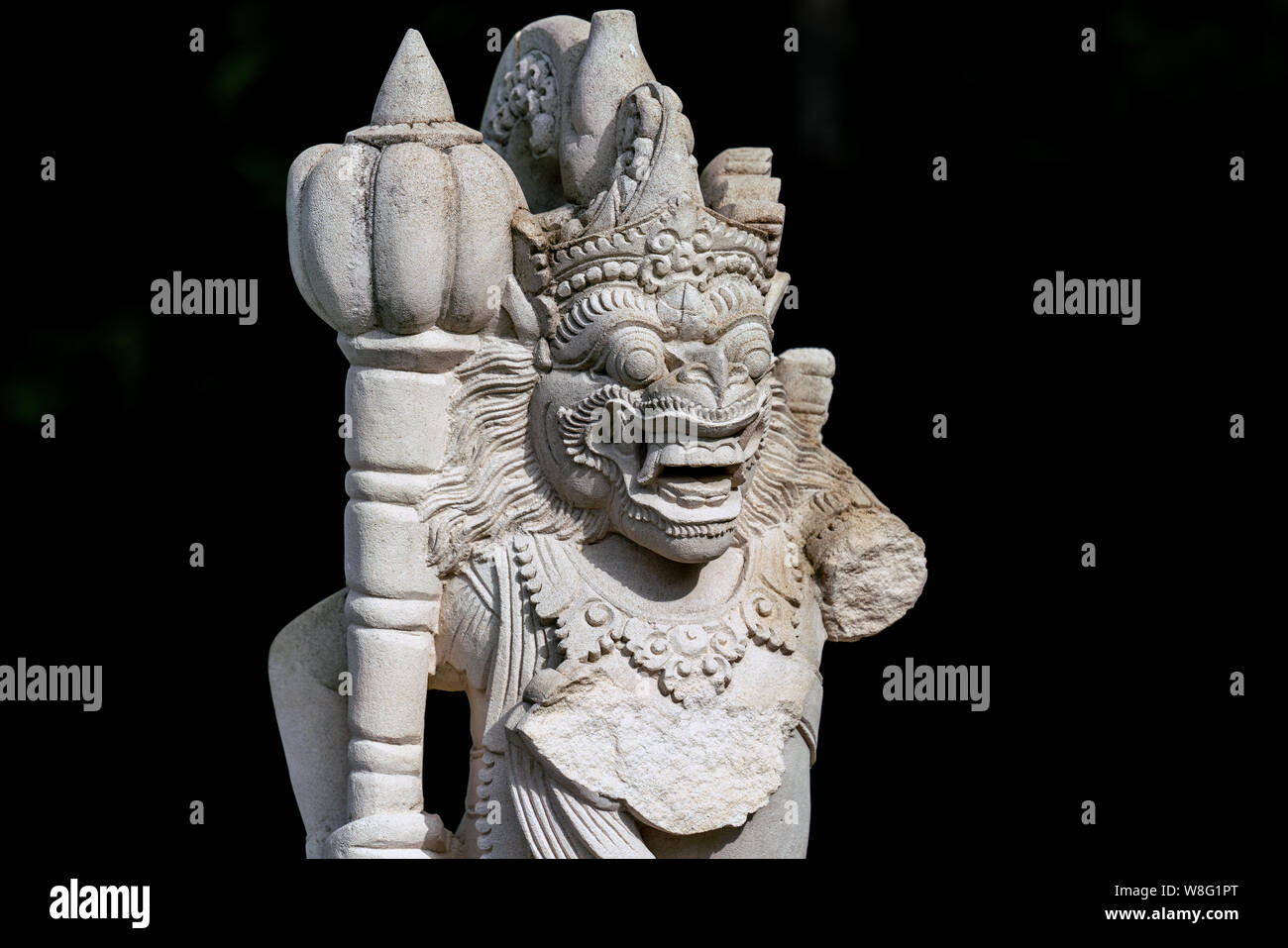 Leggermente danneggiato giardino statua di un tempio Balinese custode manca un braccio Foto Stock