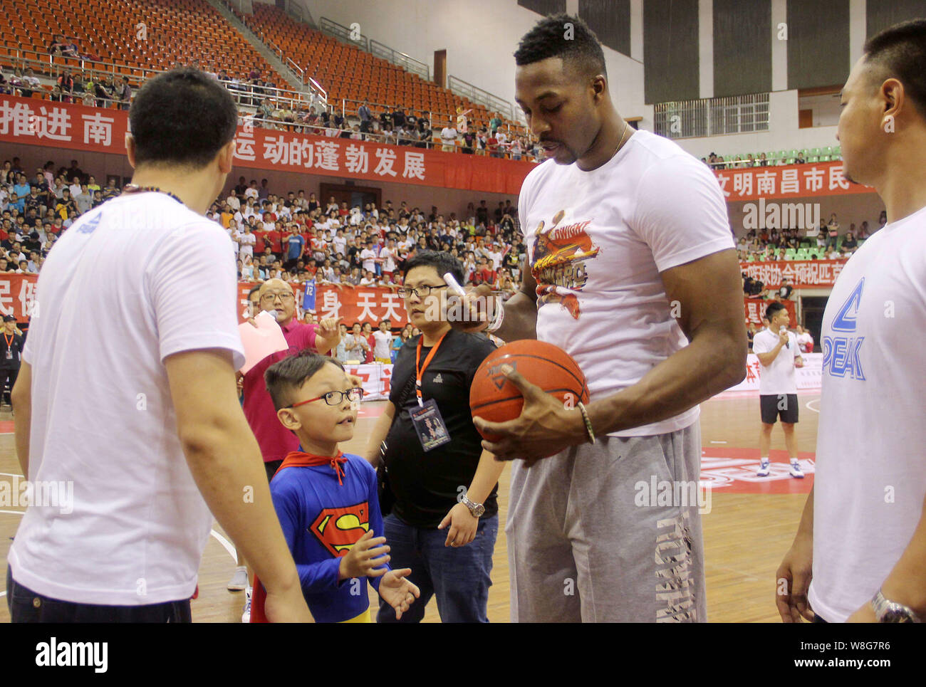 Stella NBA Dwight Howard, seconda a destra, segni il suo autografo su una partita di basket per un po' la ventola a una partita di basket evento durante il suo tour in Cina di Nanchang cit Foto Stock