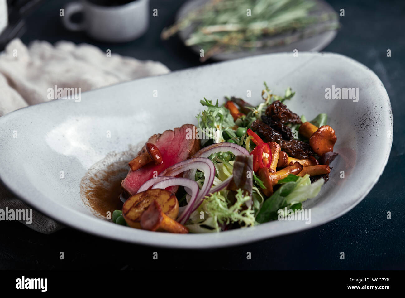 Tagliata di manzo con verdure. Close-up, chiave di basso, uno sfondo grigio. Foto Stock