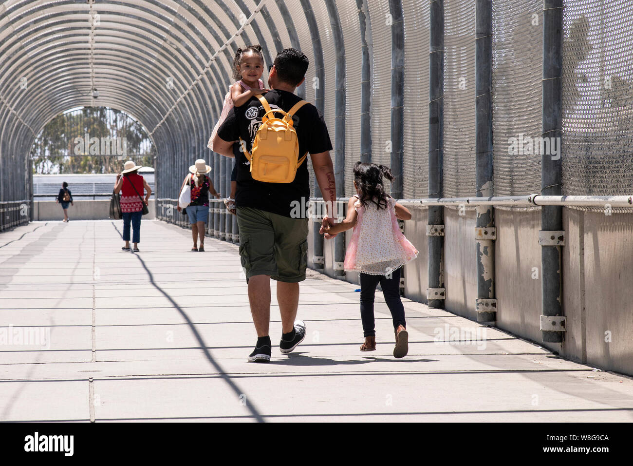 La gente a piedi attraverso un ponte pedonale all'Otay Mesa porto di entrata, per raggiungere la porta di ingresso del Messico, in San Diego CA, il 14 luglio 2019. Foto Stock