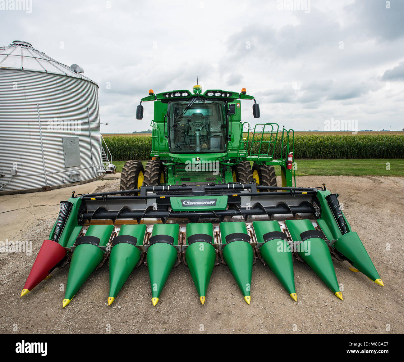 John Deere Harvester parcheggiato su un'Illinois fattoria, campo di mais in background Foto Stock
