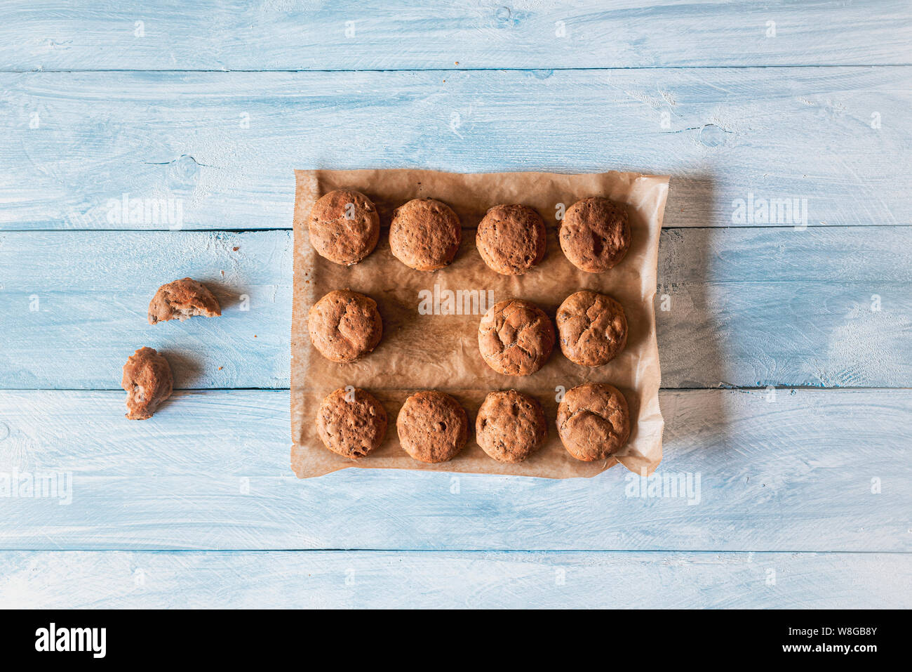 Appena il pane casereccio panini con farina di segale e le nocciole su carta da forno su un piano portapaziente bianco. Il minimo sano cibo di base. Al di sopra di vista del mini pane Foto Stock