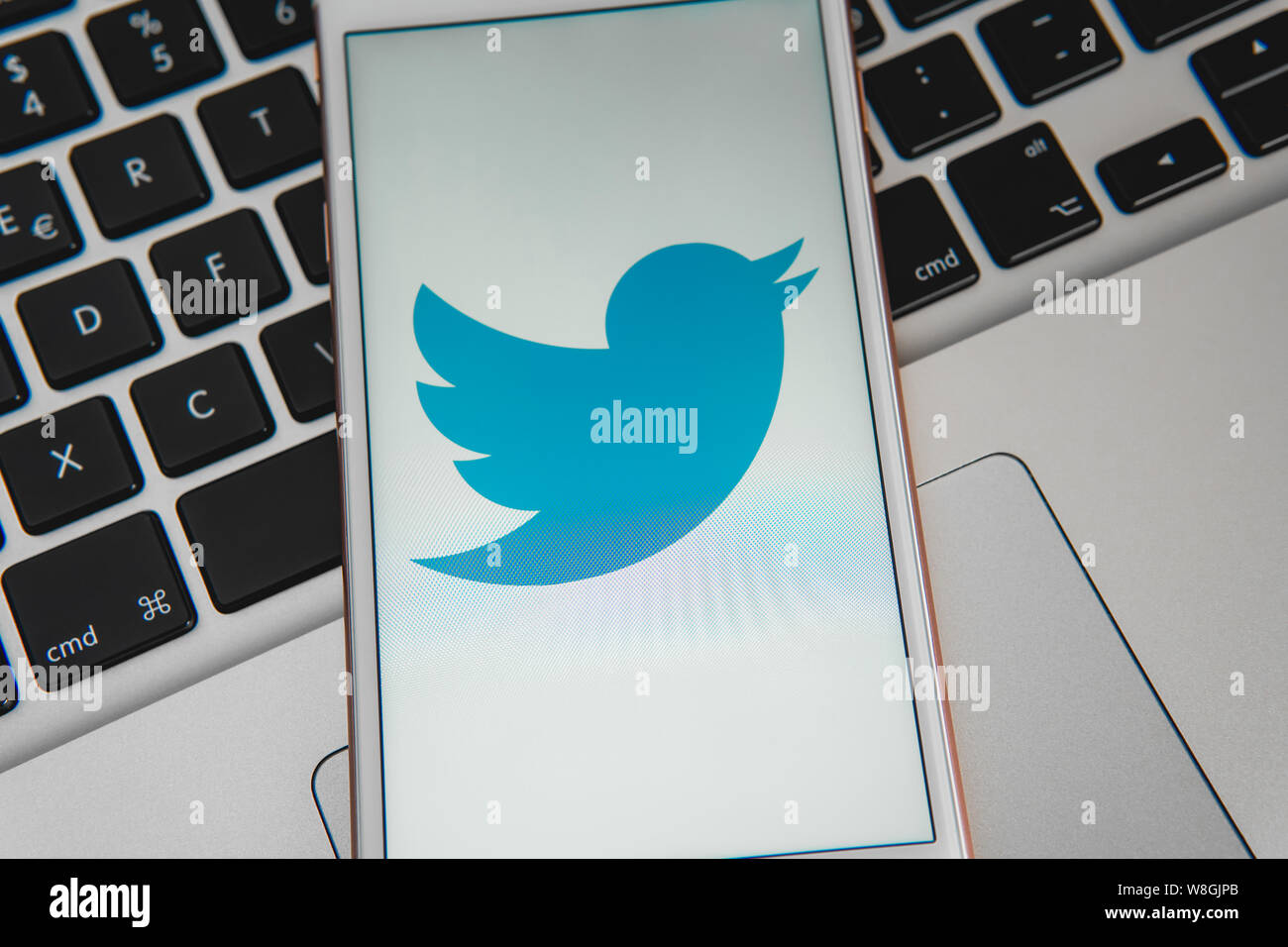 IPhone bianco con il logo dei social media Twitter sullo schermo. Social media icona. Tastiera portatile sfondo. Può essere utilizzato come concetto di marketing Foto Stock