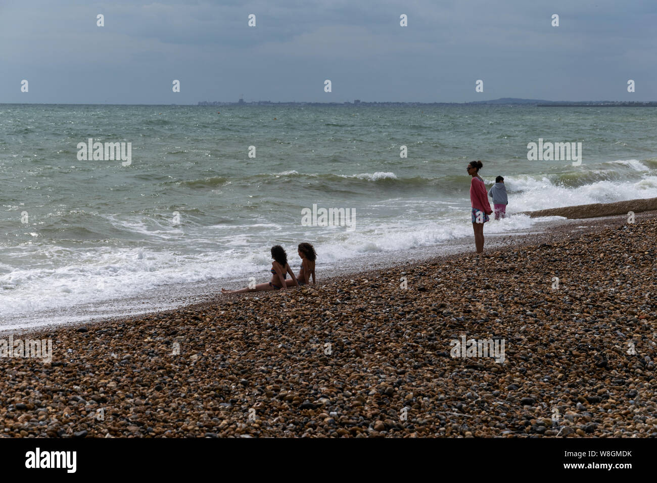 Hardy bagnanti sulla spiaggia in una fredda Luglio, Brighton, Sussex, Inghilterra Foto Stock