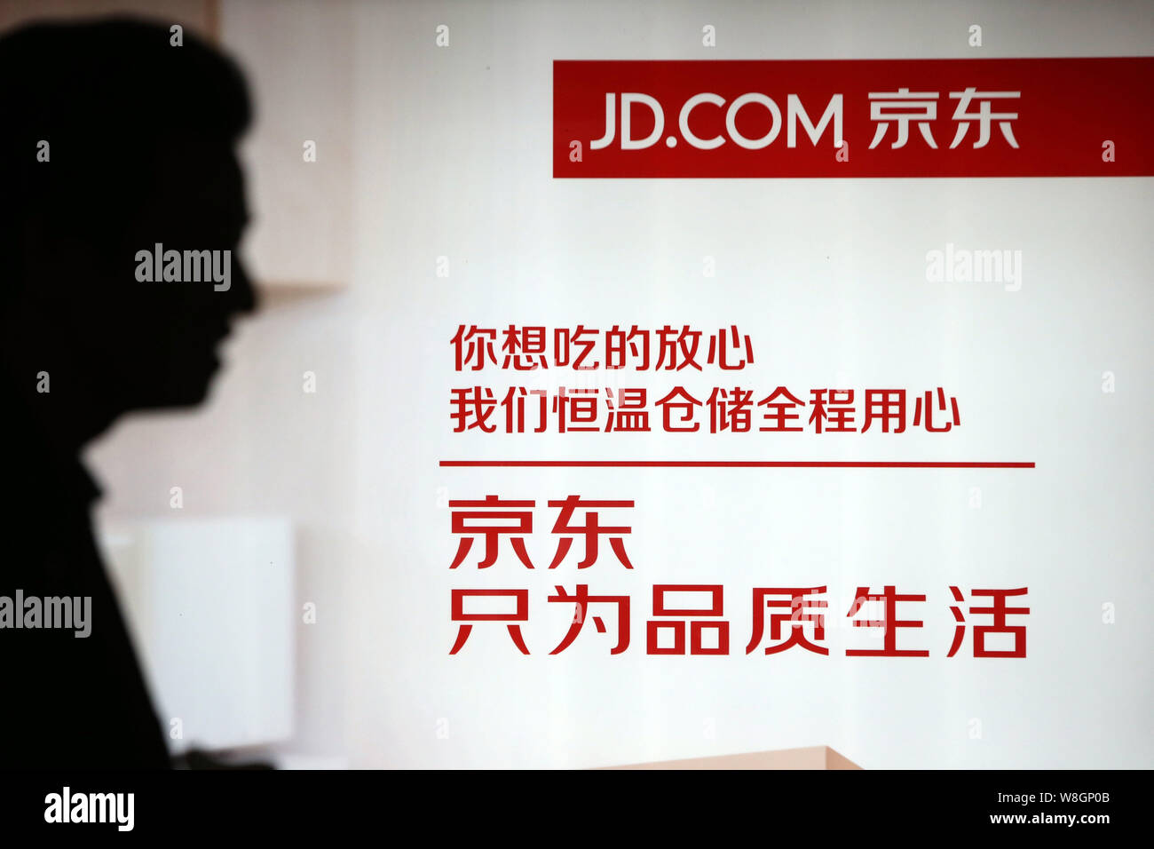 --FILE--A passeggiate a piedi passato un annuncio pubblicitario per il cinese rivenditore online JD.com in Cina a Shanghai, 2 dicembre 2015. Della Cina di vendita diretta on-line Foto Stock