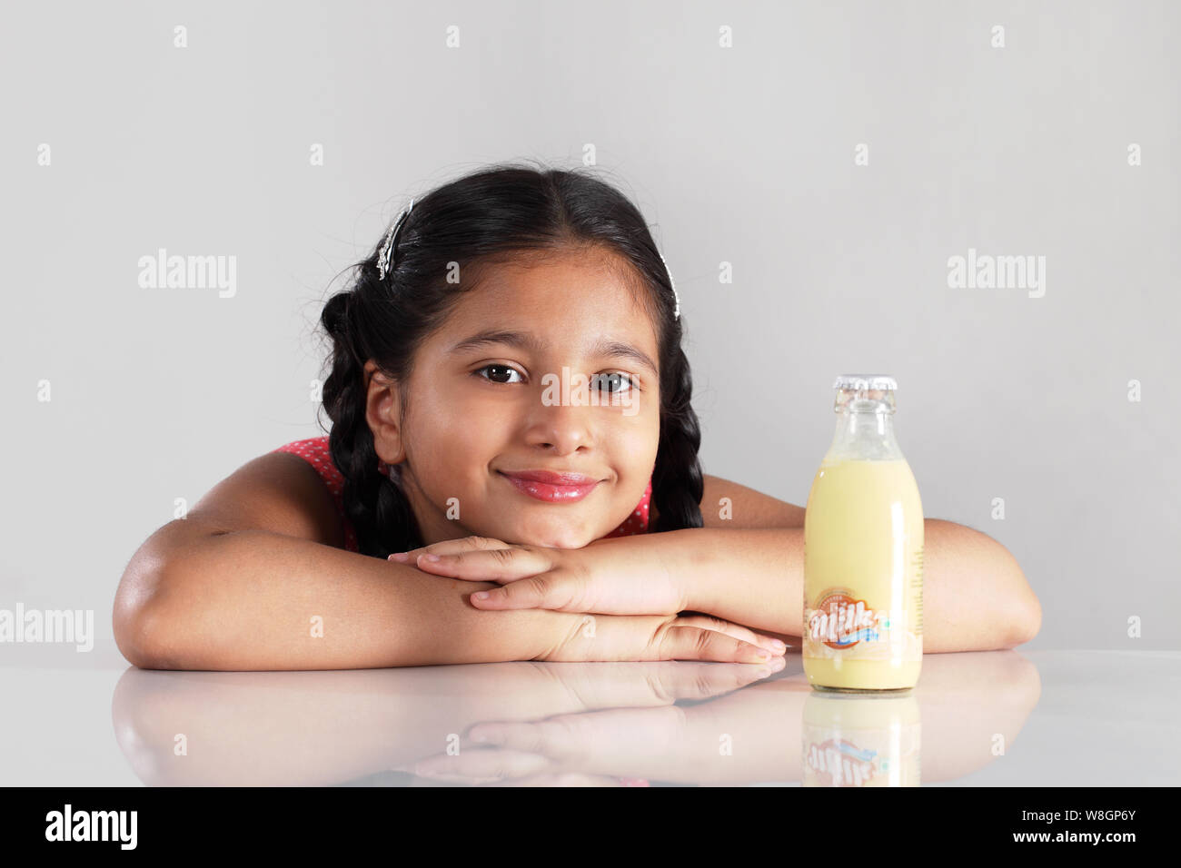 Ragazza con bottiglia su un tavolo da pranzo Foto Stock