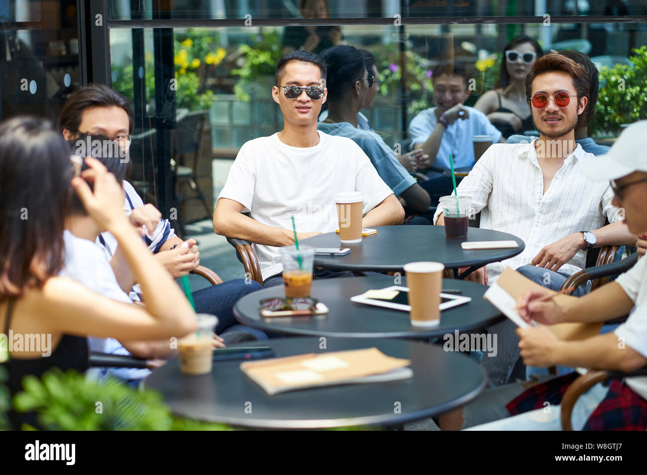 Giovani asiatici amici adulti raccolta in relax outdoor coffee shop Foto Stock