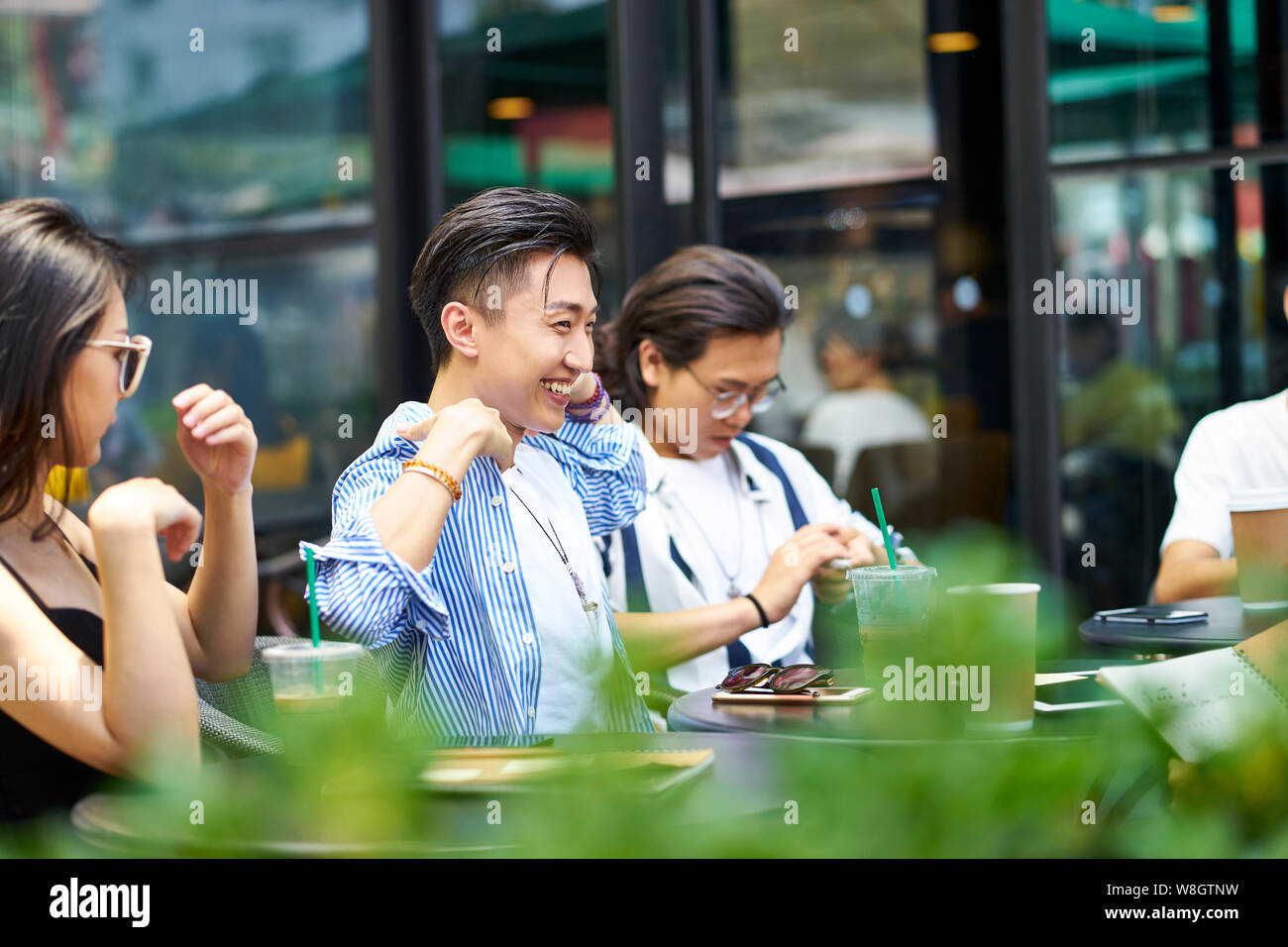 Giovani asiatici amici adulti raccolta in relax outdoor coffee shop Foto Stock