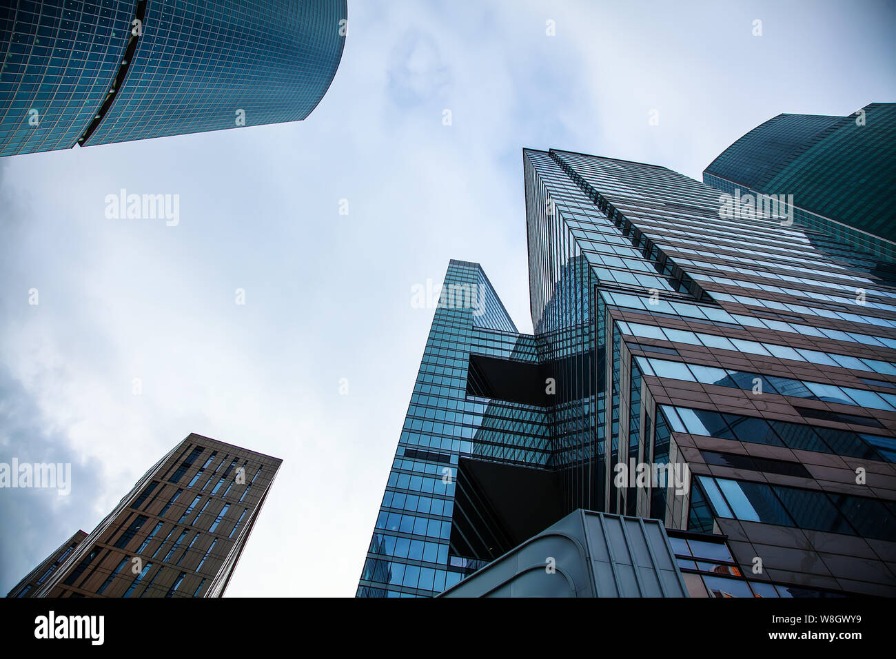 Vista della sommità di moderni grattacieli di vetro contro il cielo blu. Architectural background aziendale Foto Stock