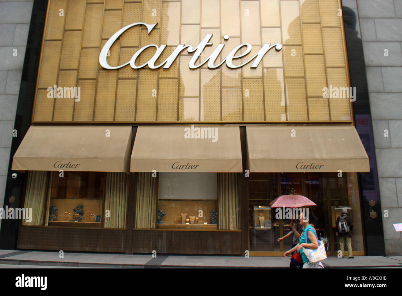 --FILE--pedoni a piedi passato una boutique di Cartier a Chongqing Cina, 2 maggio 2015. L'oro e diamanti di Cartier gioielli sono così popolari con wo Foto Stock