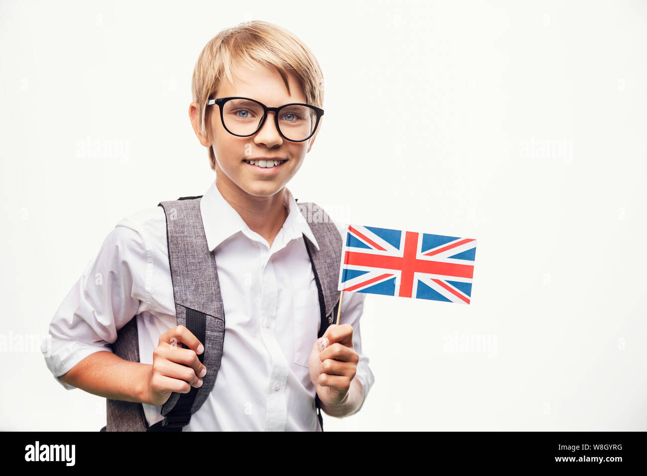 Pupilla sorridente in bicchieri azienda bandiera britannica Foto Stock