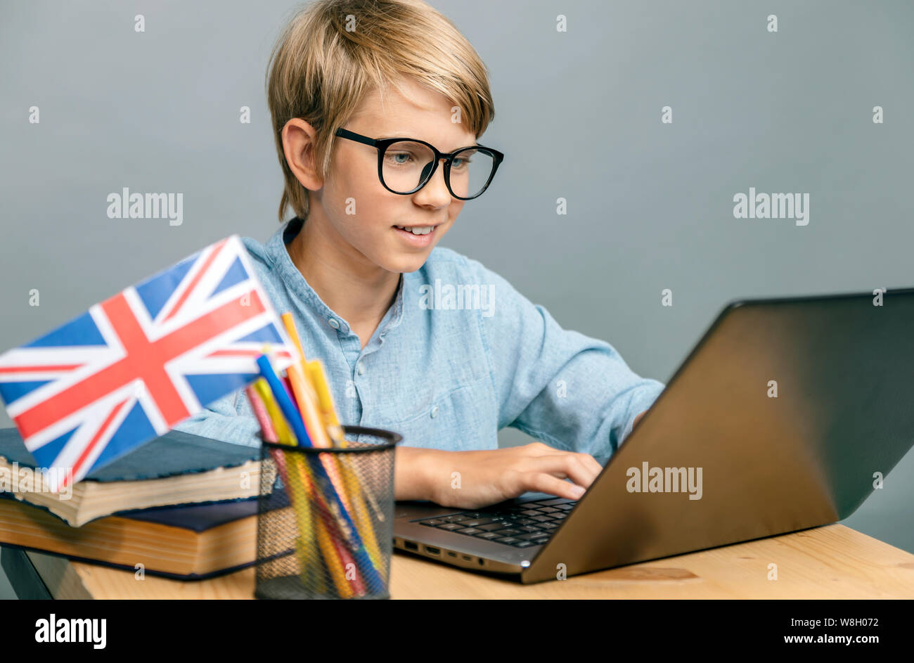 Pupilla entusiasta in bicchieri studiare inglese dal portatile Foto Stock