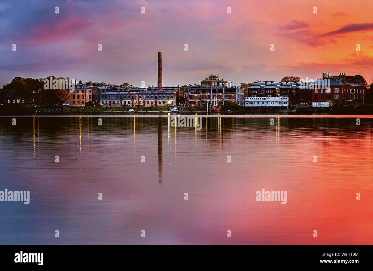 Bellissimo scatto di una città sul lago sotto un cielo rosa Foto Stock