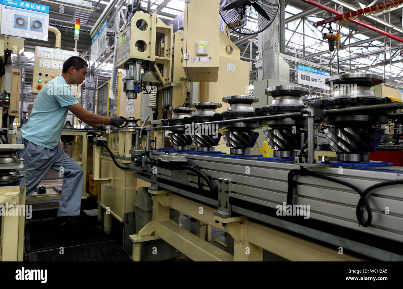 --FILE--un lavoratore cinese elabora ricambi auto presso una fabbrica nella città di Rizhao, est della Cina di provincia di Shandong, 3 giugno 2015. La Cina del tasso di crescita del PIL nell't Foto Stock