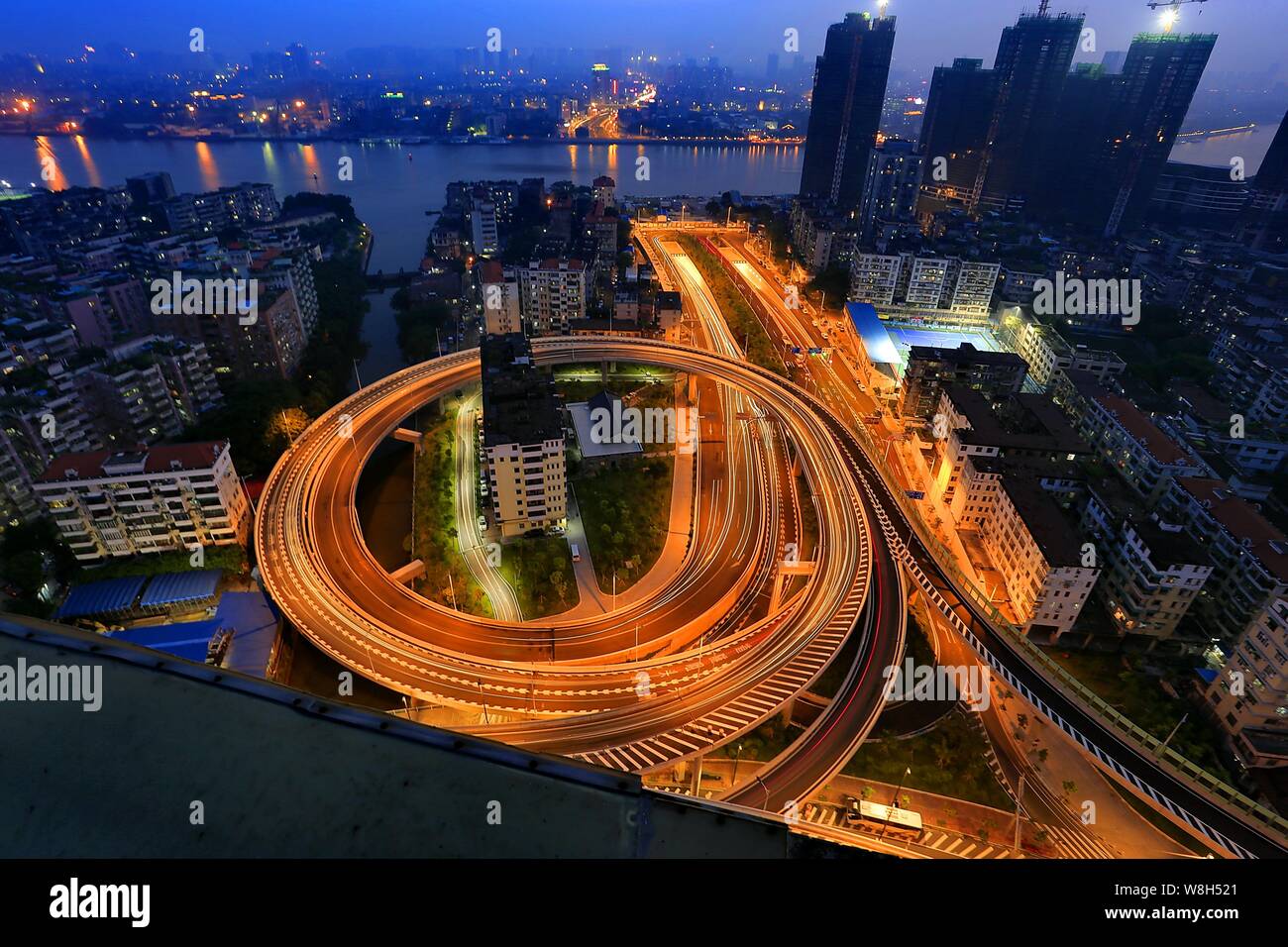 Notte Vista aerea dei due 'nail case " circondata da un cavalcavia che collega il tunnel Zhoutouzui nella città di Guangzhou, a sud della Cina di Guangdong provin Foto Stock