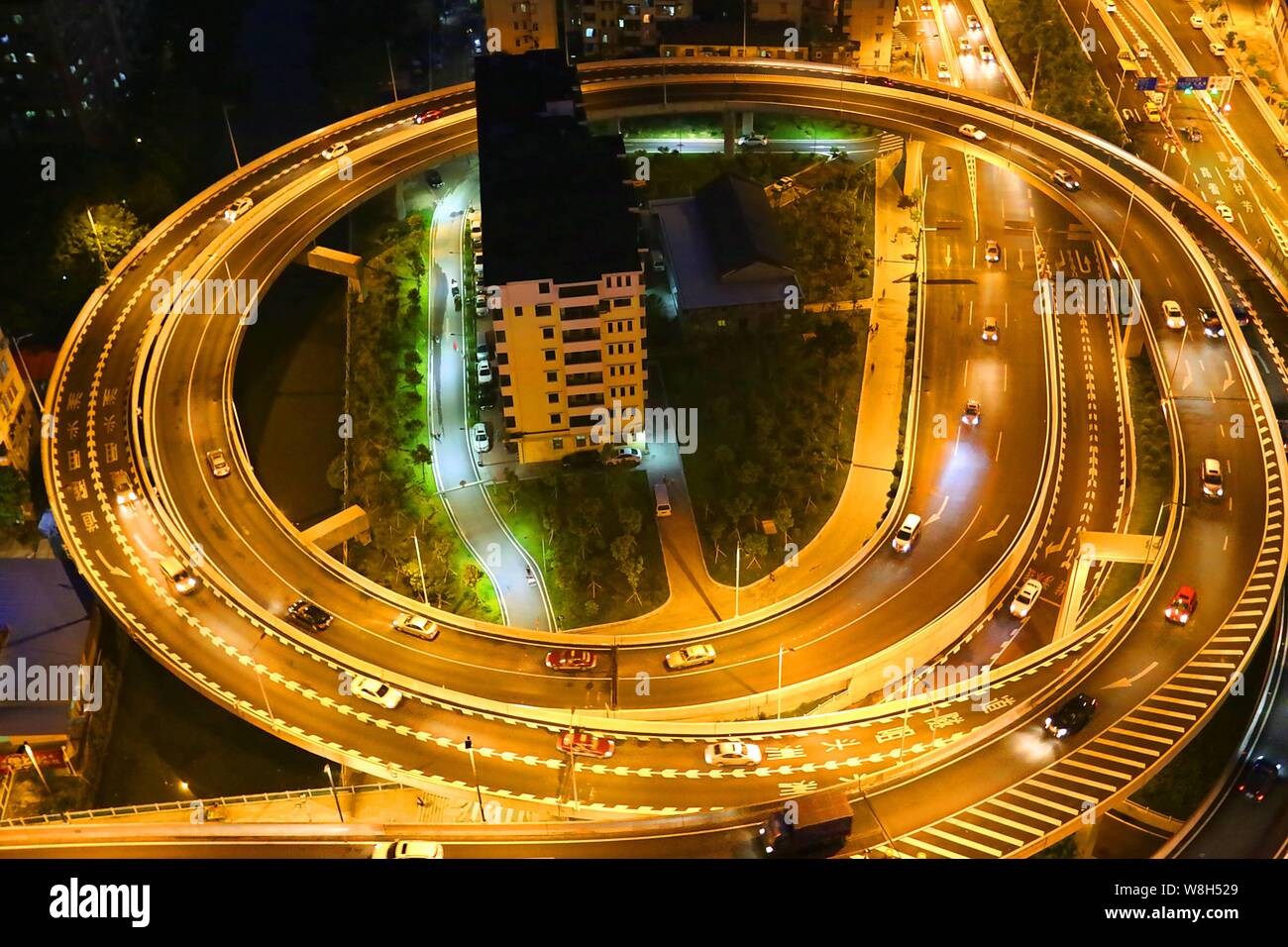 Notte Vista aerea dei due 'nail case " circondata da un cavalcavia che collega il tunnel Zhoutouzui nella città di Guangzhou, a sud della Cina di Guangdong provin Foto Stock