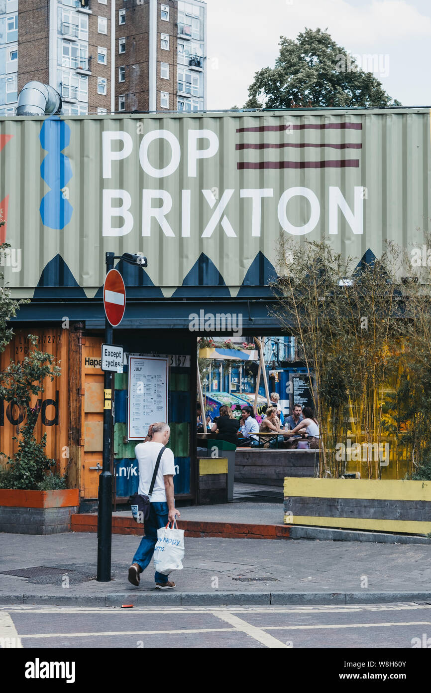 London, Regno Unito - 16 Luglio 2019: l'uomo a piedi nella parte anteriore del Pop Brixton, luogo dell'evento e la casa di una comunità di rivenditori indipendenti, ristoranti, street Foto Stock
