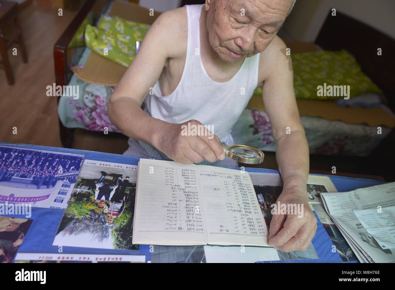 Il 97-anno-vecchio magazzino cinese investor Shi Kunsen guarda attentamente le info di negoziazione di azioni ha raccolto a casa nella città di Hangzhou, a est della Cina di Zhejia Foto Stock