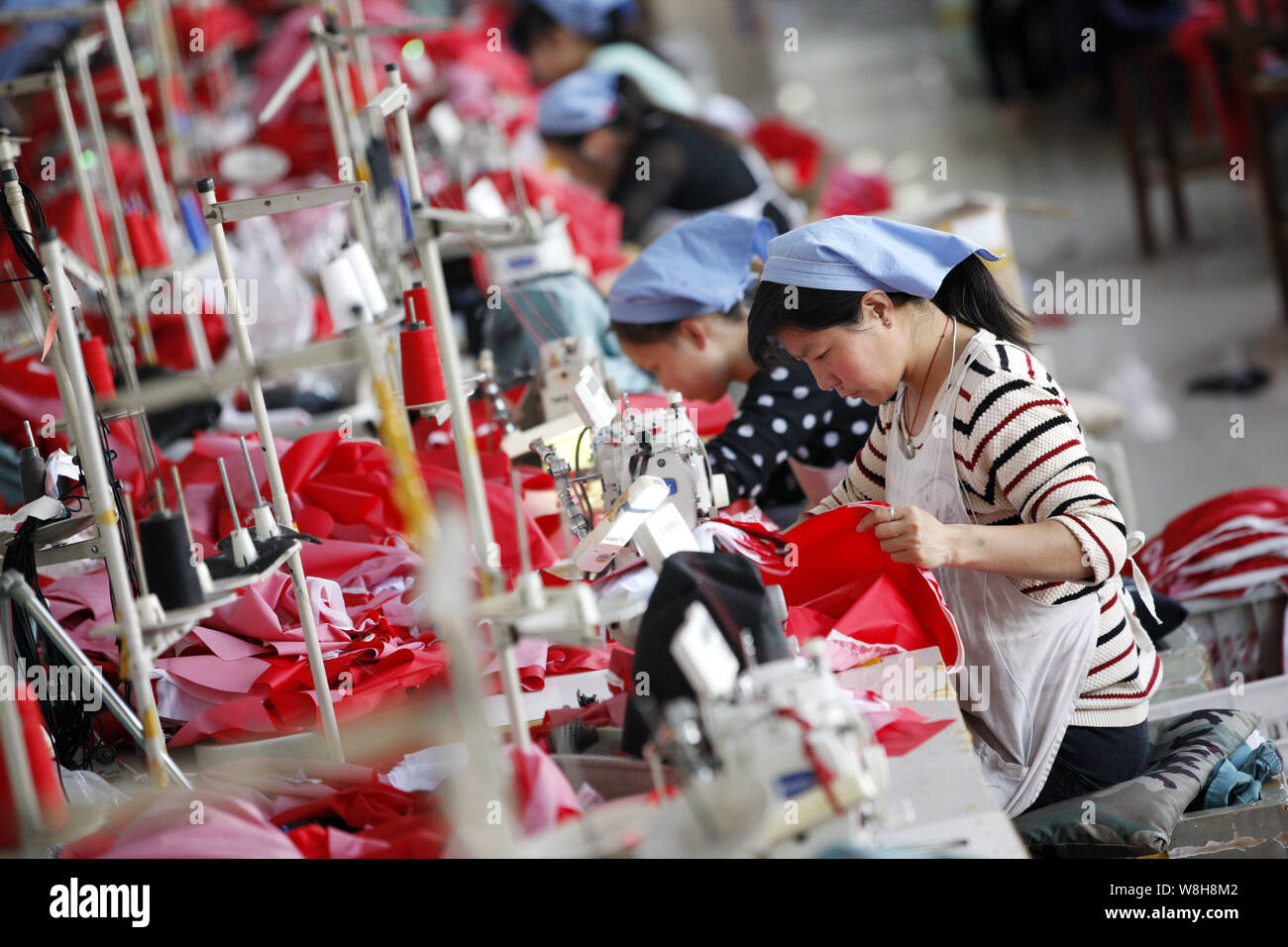--FILE--femmina di lavoratori cinesi cucire vestiti a una fabbrica di indumento in città Huaibei, est cinese della provincia di Anhui, 13 ottobre 2015. Della Cina di crescita del PIL Foto Stock