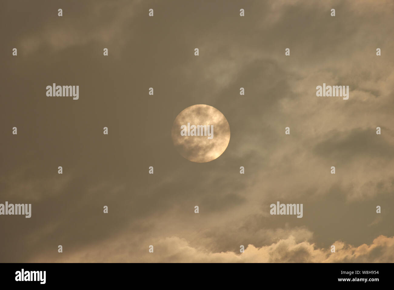 Il disco del sole risplende attraverso le nuvole e la nebbia. Foto Stock