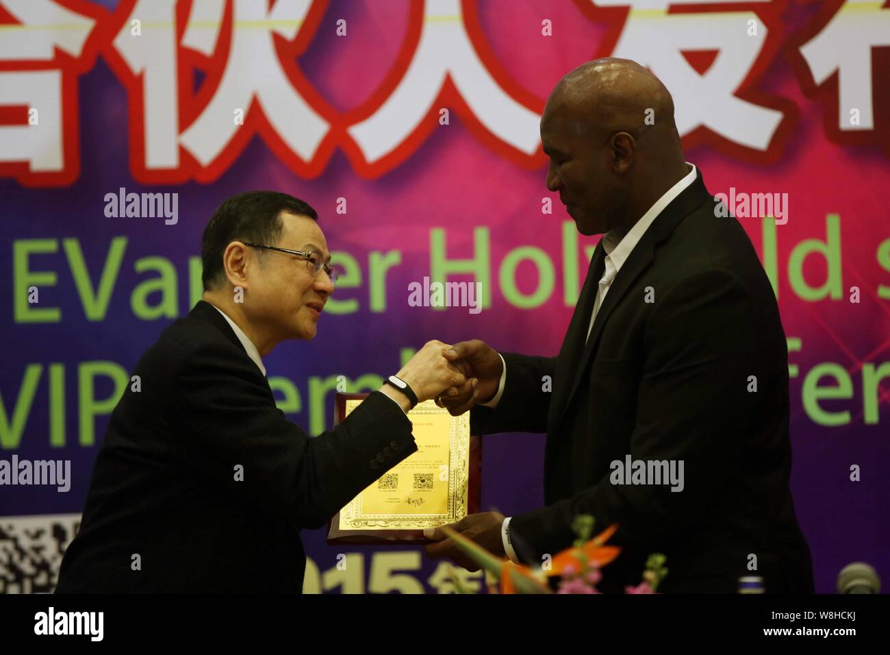 American boxing campione del mondo Evander Holyfield, destra, scuote le mani con Pietro Huang Ming-Tuan, Direttore esecutivo di Sun Arte Retail Group Limited un Foto Stock