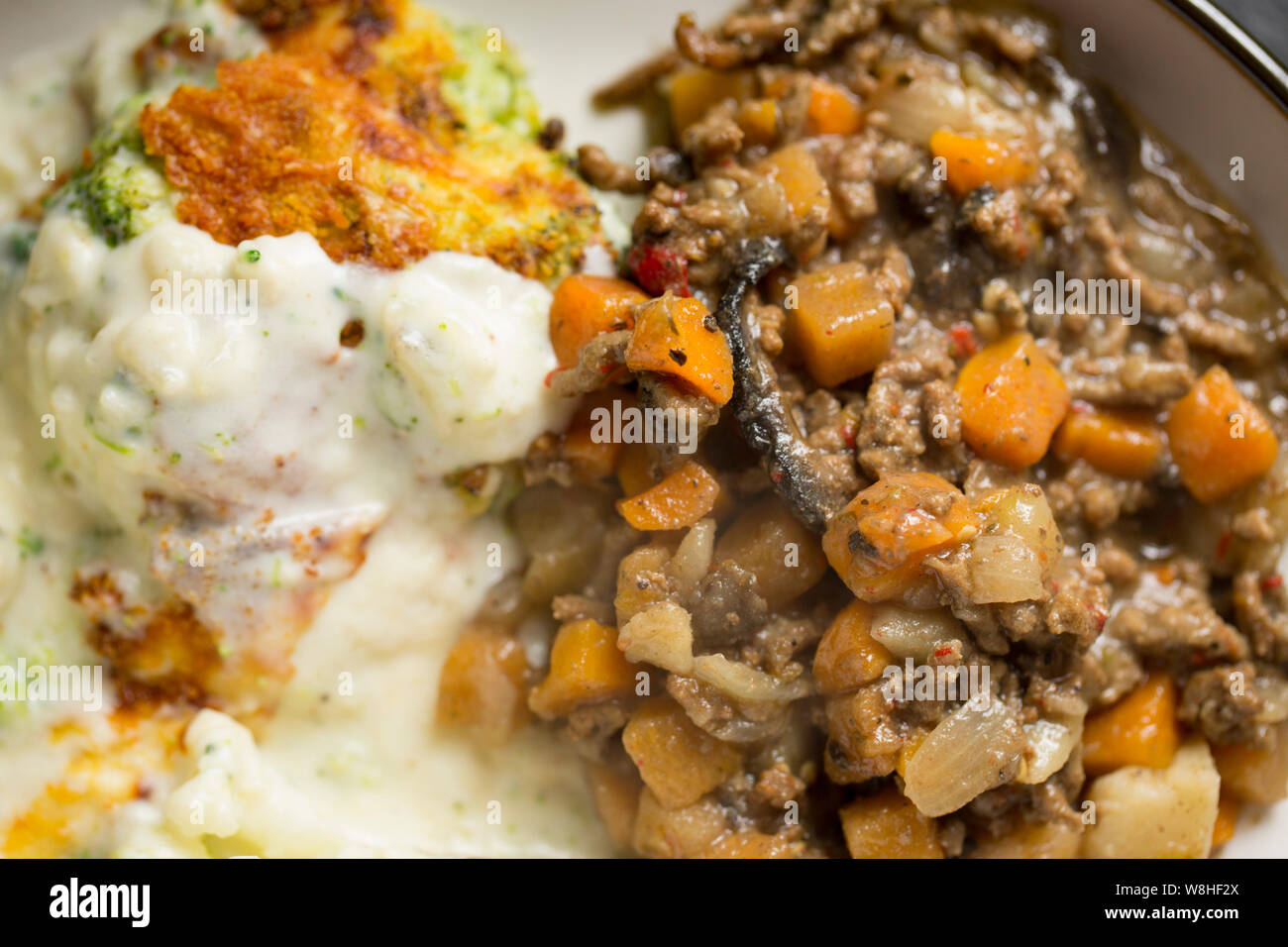 Fried British carni macinate e verdure servita con un Cavolfiori e cavoli broccoli formaggio prodotto con matura il formaggio Cheddar e guarnita con golden breadcru Foto Stock