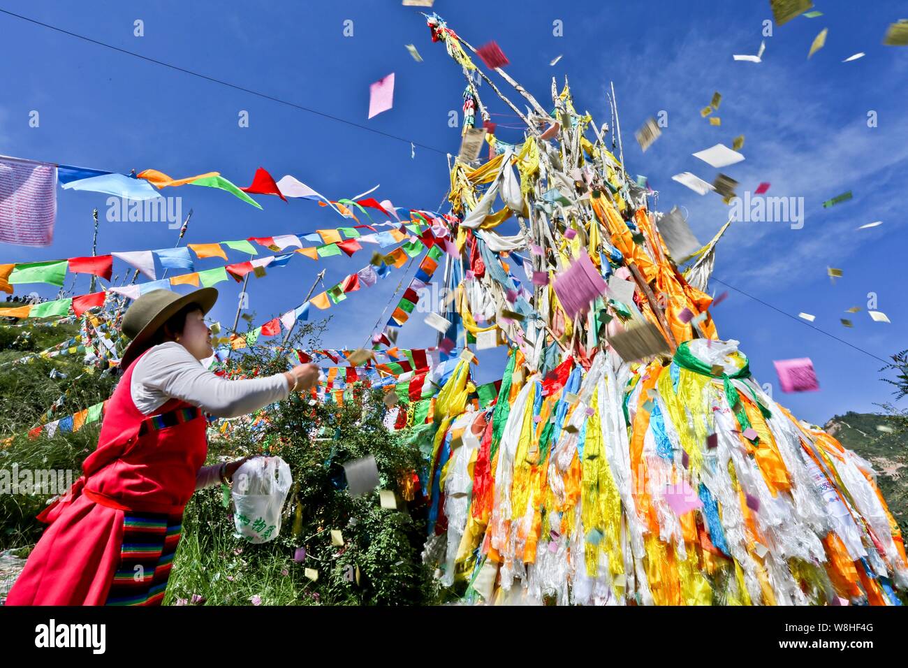 Una donna tibetana adora le bandiere di preghiera durante il sole di Buddha Festival (Shaifo Jie) nel tempio di Mati in Sunan Yugur contea autonoma, Northwest Ch Foto Stock