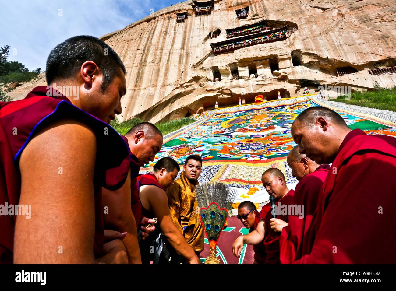 I lama culto un enorme Thangka di Buddha durante il sole di Buddha Festival (Shaifo Jie) nel tempio di Mati in Sunan Yugur contea autonoma, Northwest C Foto Stock