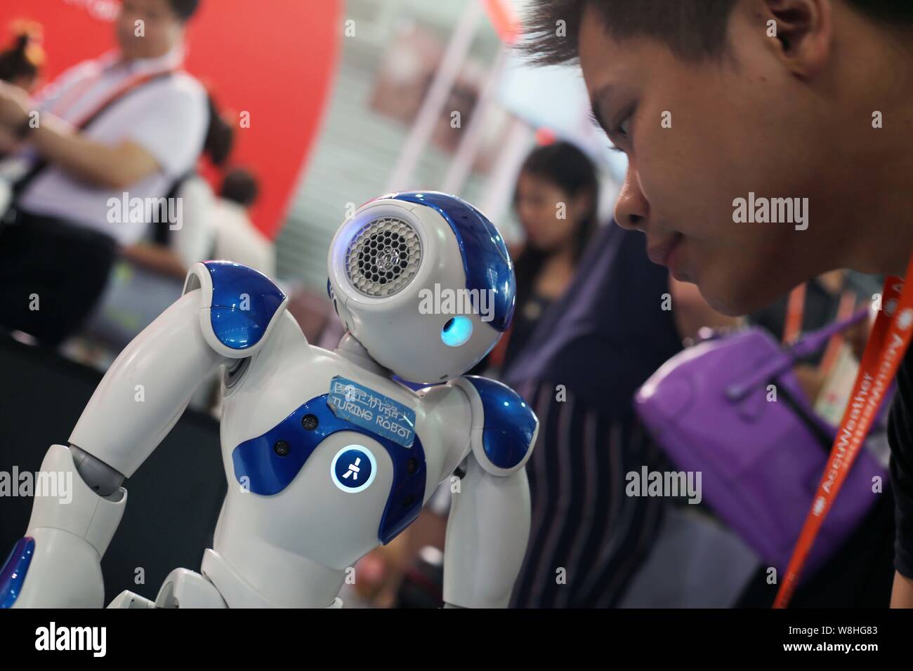 Un visitatore interagisce con un Turing robot umanoide durante  l'International Consumer Electronics Show Asia (International CES Asia) in  Cina a Shanghai Foto stock - Alamy