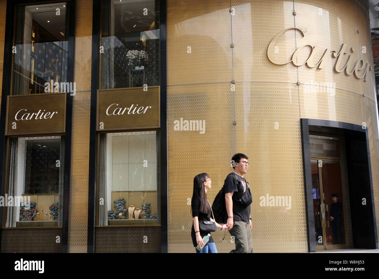 --FILE--pedoni a piedi passato una boutique di Cartier in Cina a Shanghai, 31 marzo 2015. Shanghai è emerso come la città più costosa per il lusso liv Foto Stock
