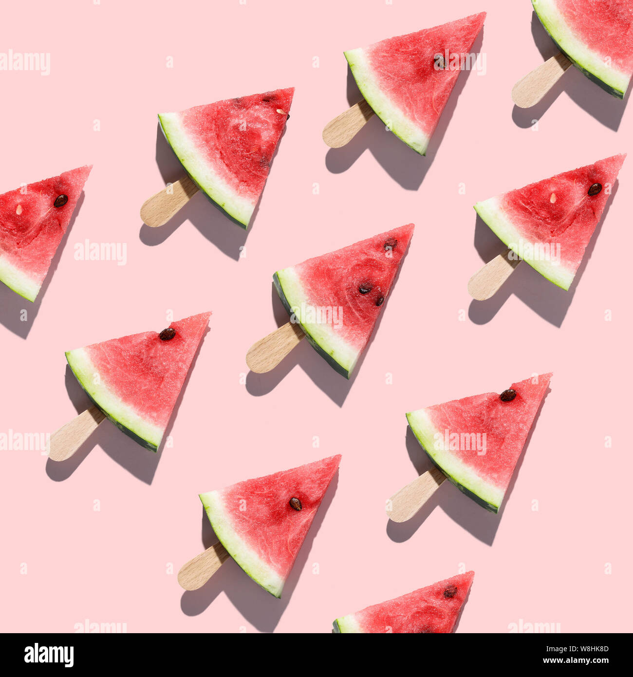 Fette di cocomeri disposti su un sfondo rosa Foto Stock