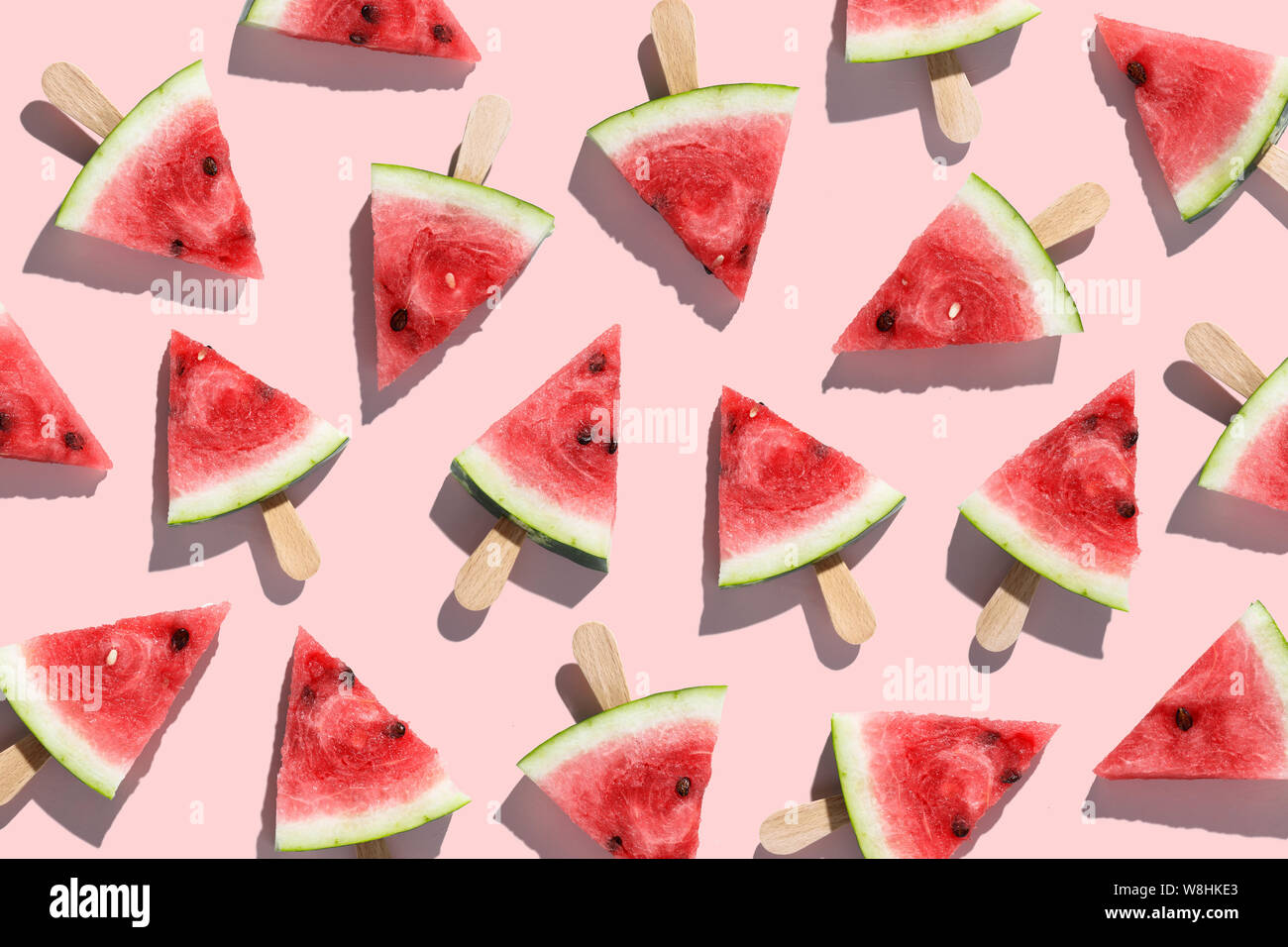 Fette di cocomeri disposti su un sfondo rosa Foto Stock