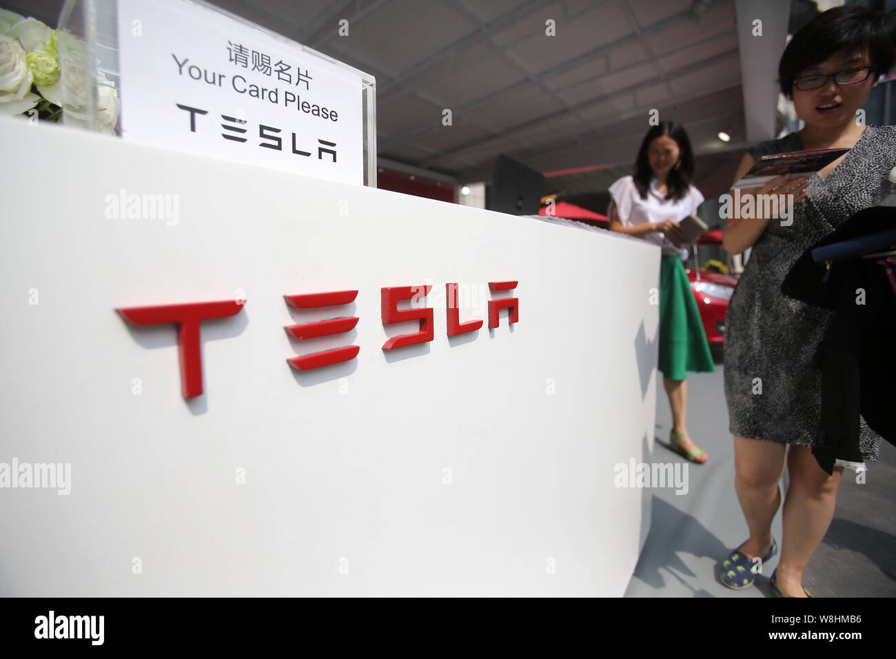 --FILE--i visitatori a piedi passato lo stand di Tesla durante un evento promozionale in Cina a Shanghai, 21 maggio 2015. Tutti di un improvviso, alcuni sell-side analisti un Foto Stock