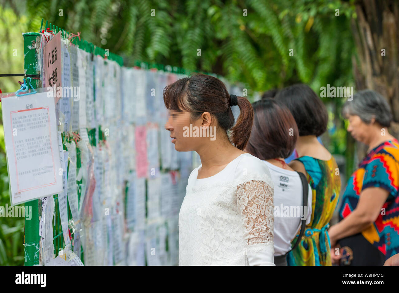 --FILE--giovani cinesi le donne guardano a posti che mostra le informazioni personali di persone non sposate all'angolo di matchmaking in un parco nella città di Shenzhen, sud Foto Stock