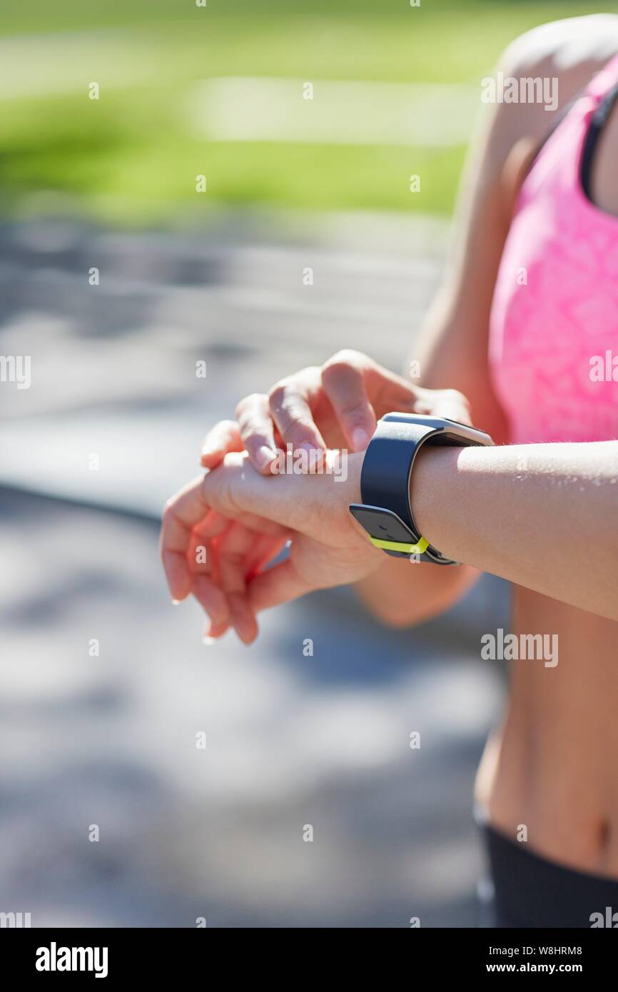 Donna che indossa orologio sportivo controllando il tempo. Foto Stock