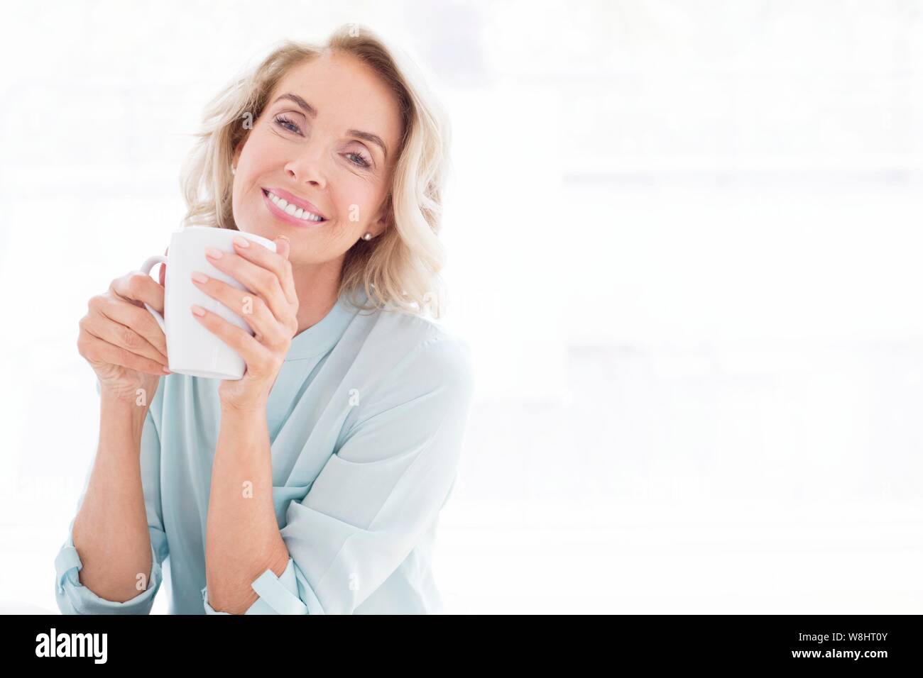 Donna matura sorridente con la tazza di tè. Foto Stock