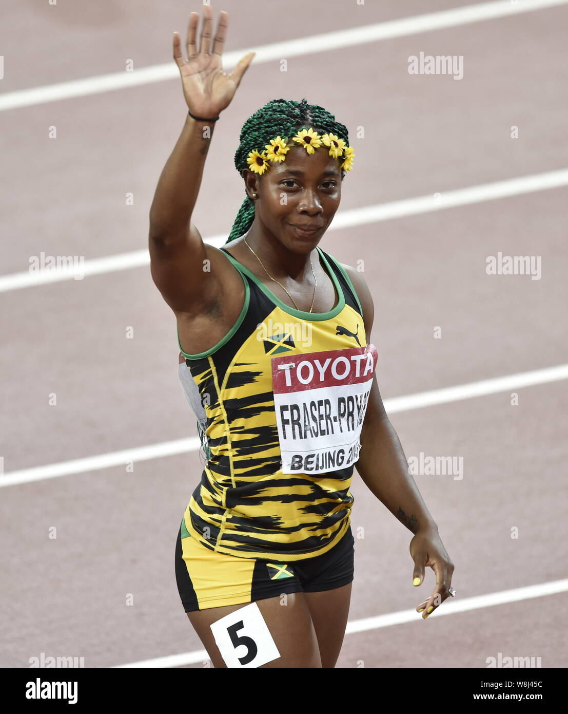 Shelly-Ann Fraser-Pryce della Giamaica onde da spettatori dopo aver vinto le donne 100m durante la finale di Pechino IAAF 2015 Campionati del Mondo a Na Foto Stock