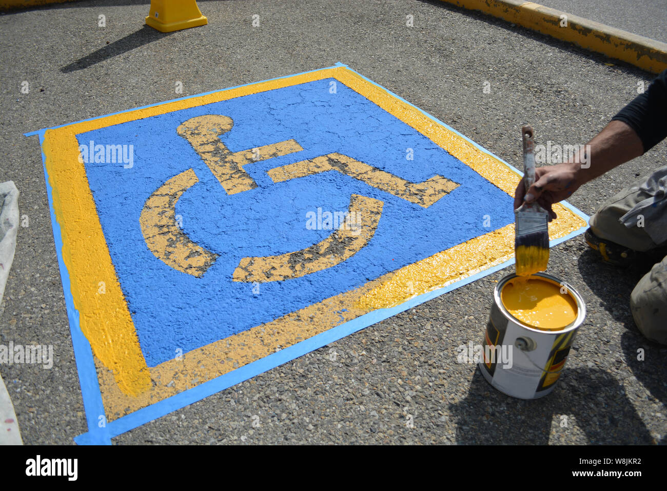 Pittore riverniciatura di handicap Parcheggio sulla pavimentazione stradale Foto Stock